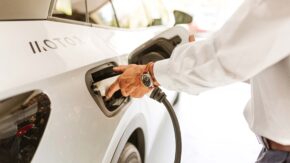 man plugging in electric vehicle