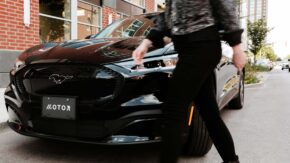 woman walking by mustang mach-e electric vehicle