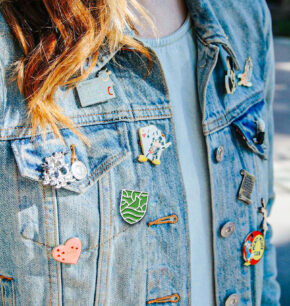 an enamel pin of the parks alliance crest worn on a jean jacket
