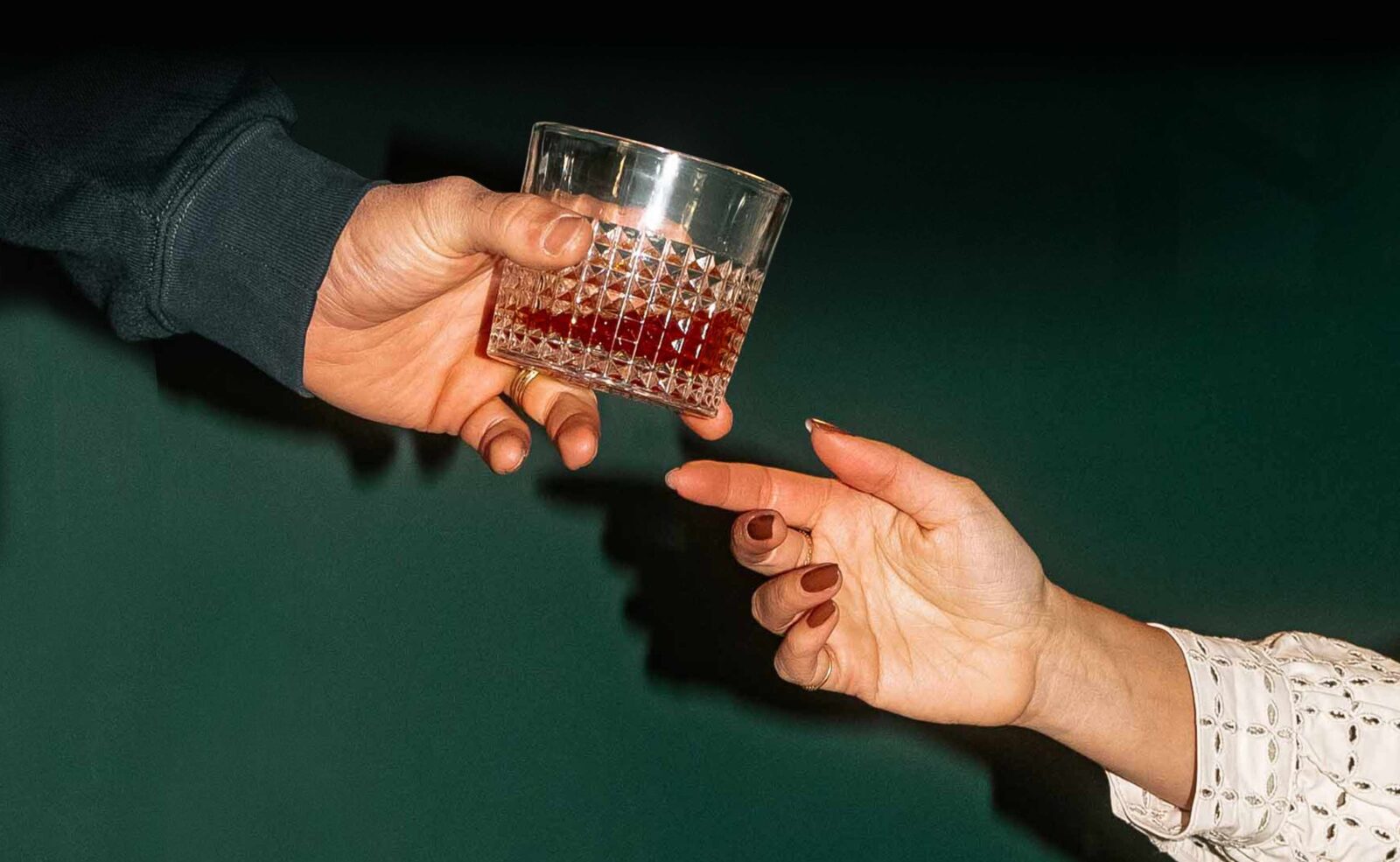a mans handing a glass of whiskey to a woman