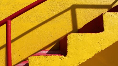 yellow staircase with red railing leading up to the right